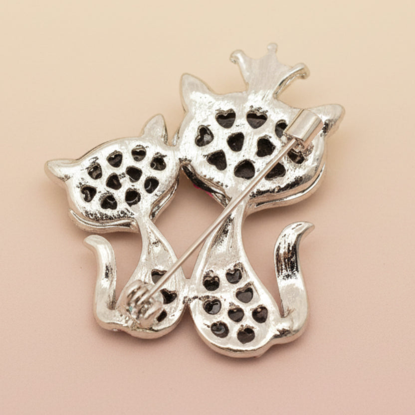 Backside of double cat brooch on a light background