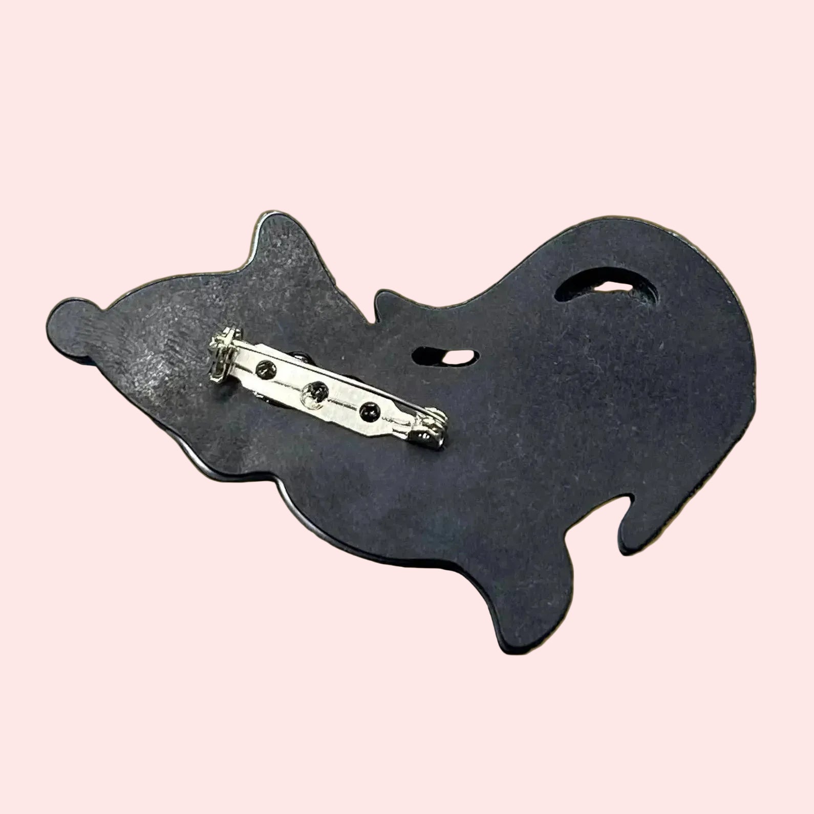 Background of black and white cat brooch wearing a blue nightcap with star patterns on a light peach background