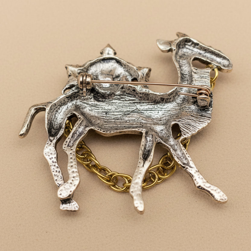 Backside of gold camel brooch on a beige background