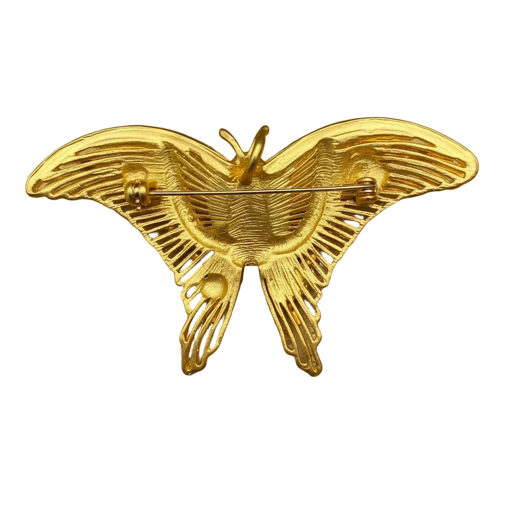 Backside golden butterfly brooch on a soft cream colored background