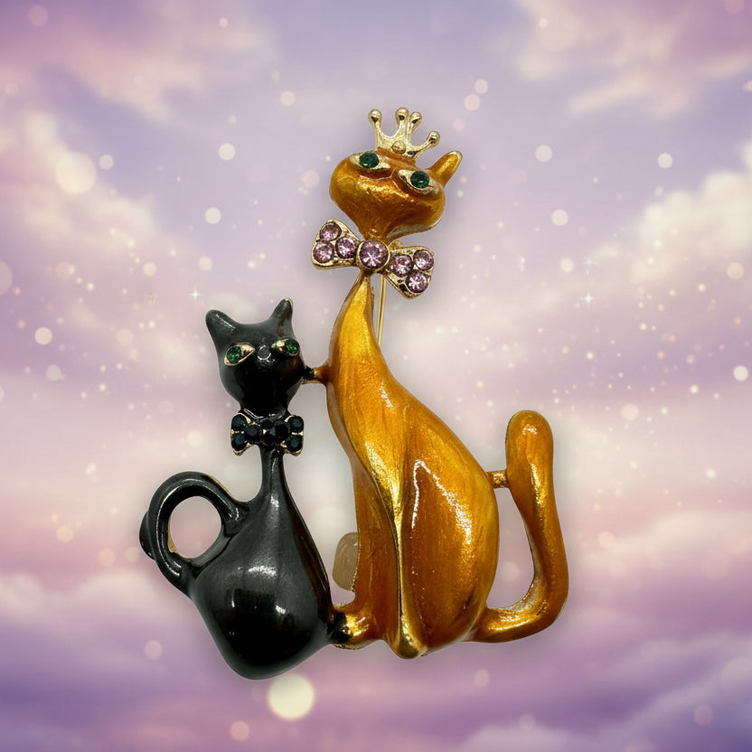 Black and orange cat sisters brooch on a light pastel background