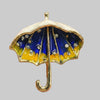 Enamel umbrella brooch with blue and yellow design on a light gray background