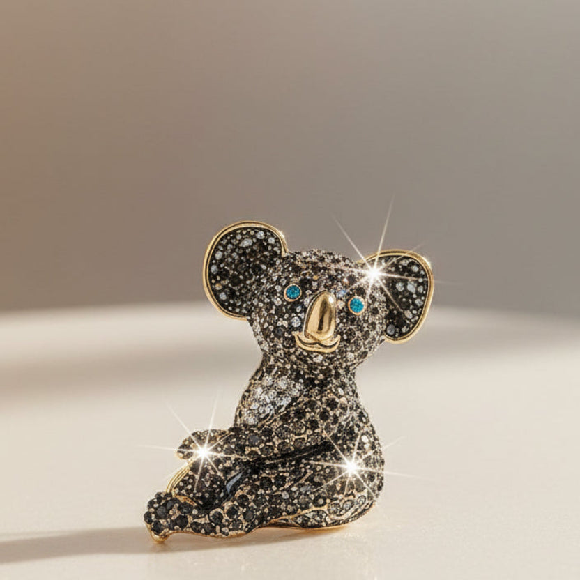 Close-up of a black rhinestone koala brooch on a light gray background