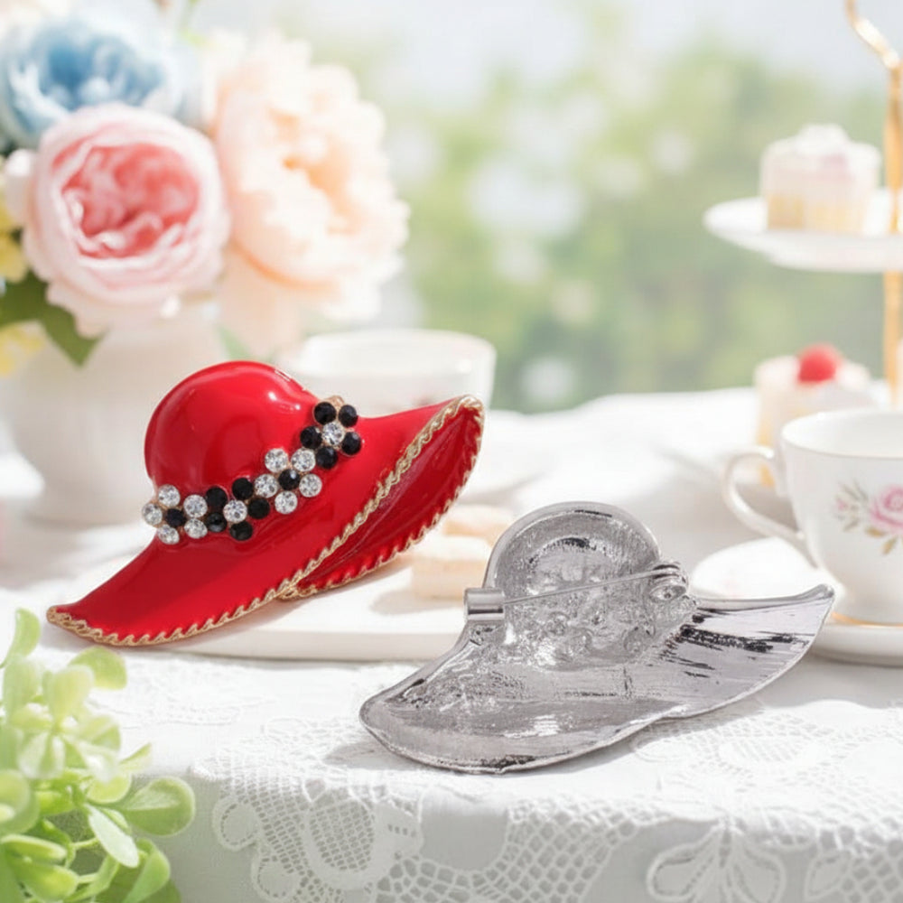 Red hat-shaped brooch with decorative elements on a white background