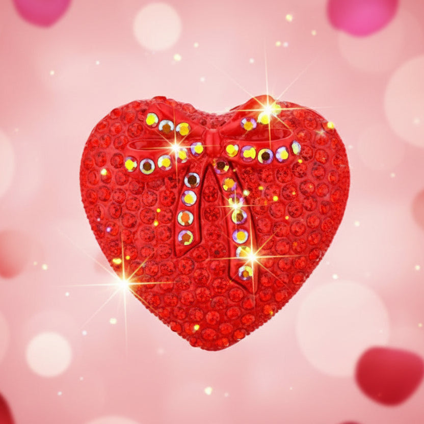 Red heart-shaped brooch with a bow and crystals on a pink hearts background