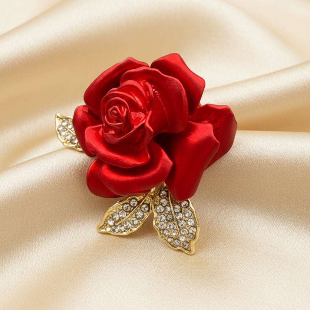 Red rose brooch with gold leaves on a ivory satin background