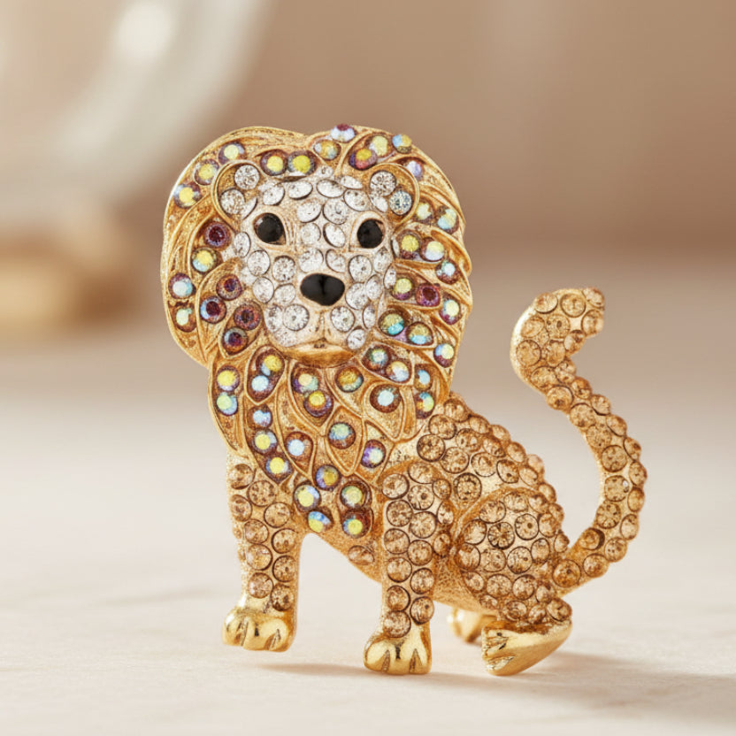 Golden rhinestone lion brooch on a soft pastel background