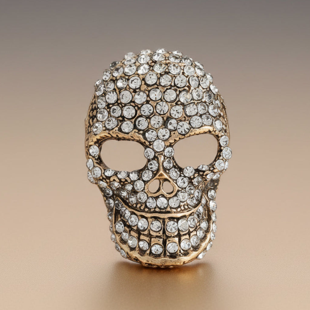 Decorative skull brooch with crystal embellishments on a soft white background