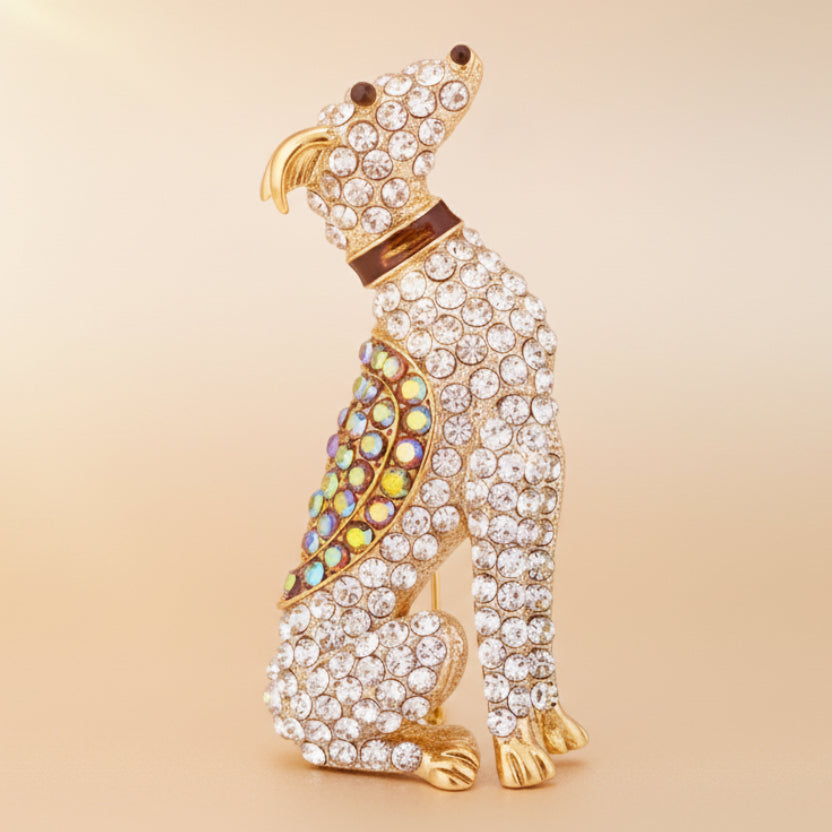 Seated hound brooch accented with gemstones on a soft beige background