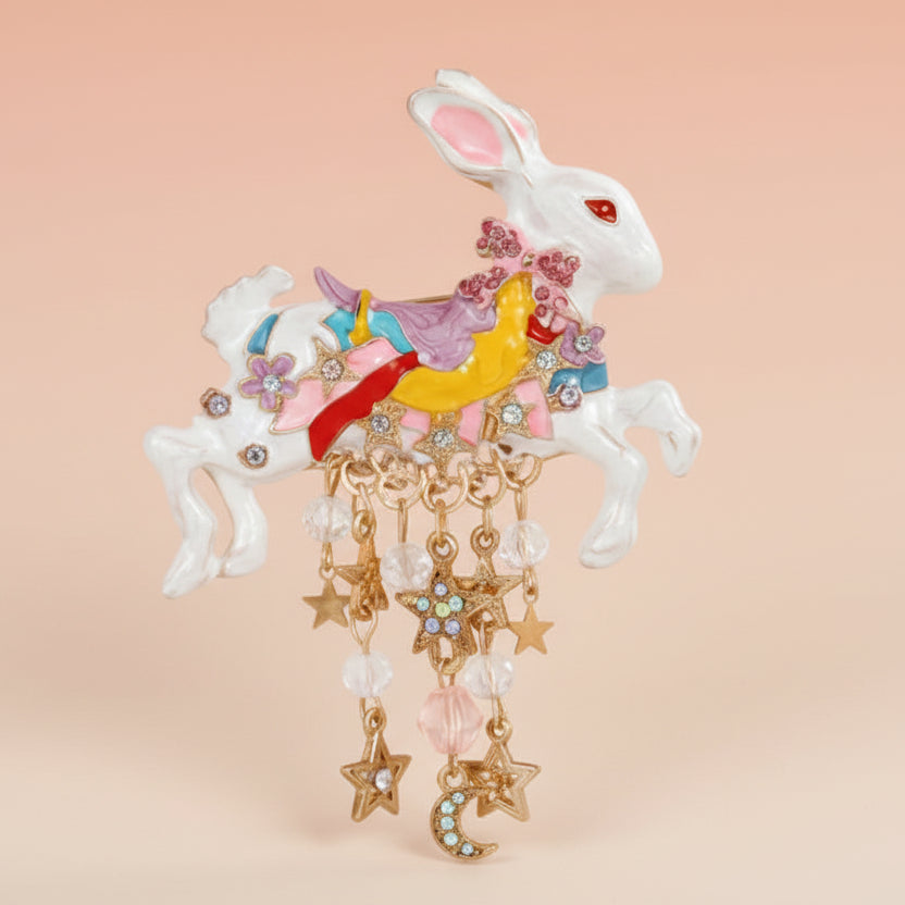 Colorful royal rabbit brooch with star and moon charms on a soft pastel background